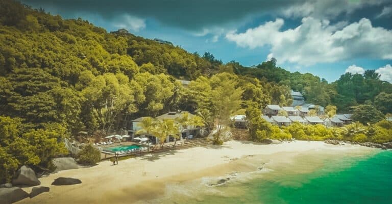 Scenic view of Carana Beach with hotel and lush greenery.