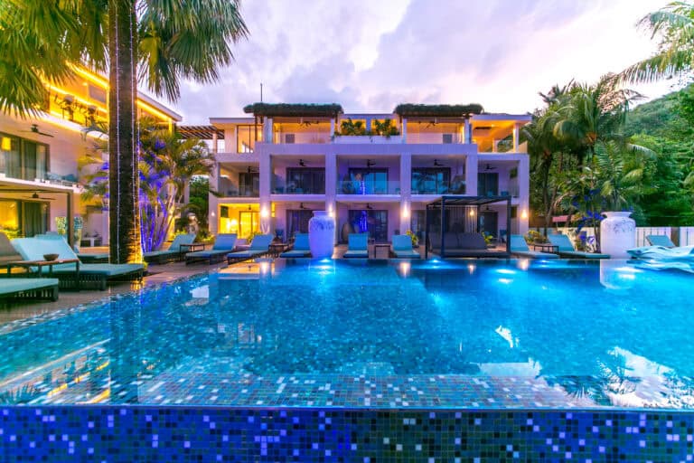 Luxury Seychelles hotel with pool, tropical gardens, and modern architecture.