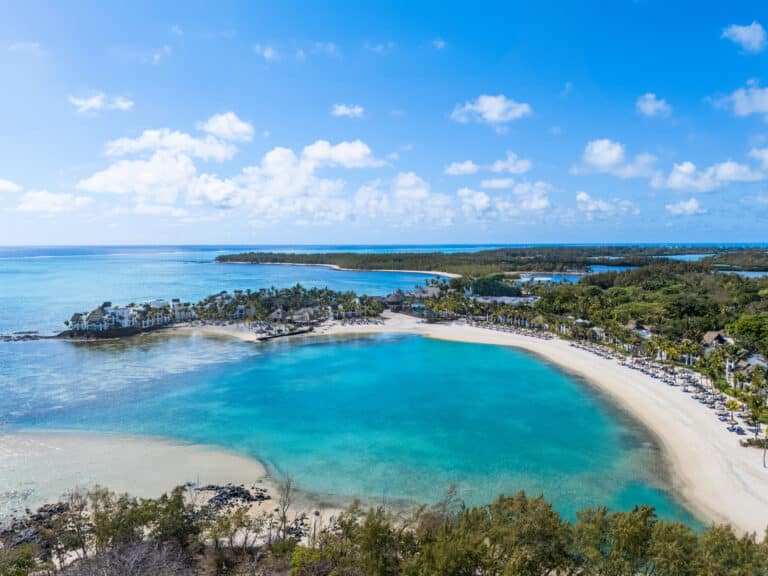 Beautiful aerial view of a tropical beach with turquoise waters and lush greenery in Mauritius.