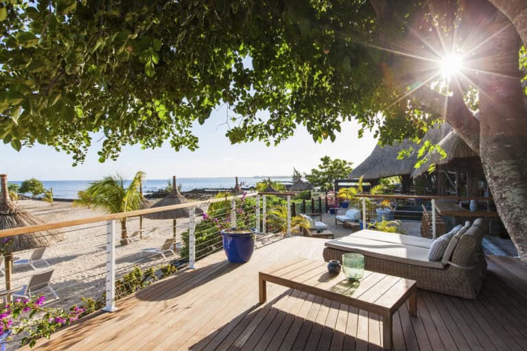 Beachfront veranda with seating and lush greenery at Veranda Pointe Aux Biches.