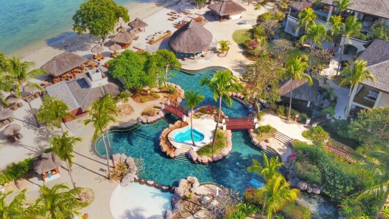 Aerial view of Hilton Mauritius Resort & Spa with pools and tropical landscape.
