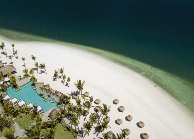 Aerial view of a luxurious Mauritian beach with a resort and turquoise waters.