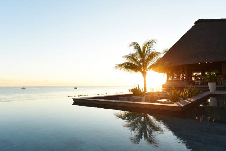 Sunset view at Veranda Paul et Virginie Hotel & Spa with pool and ocean.
